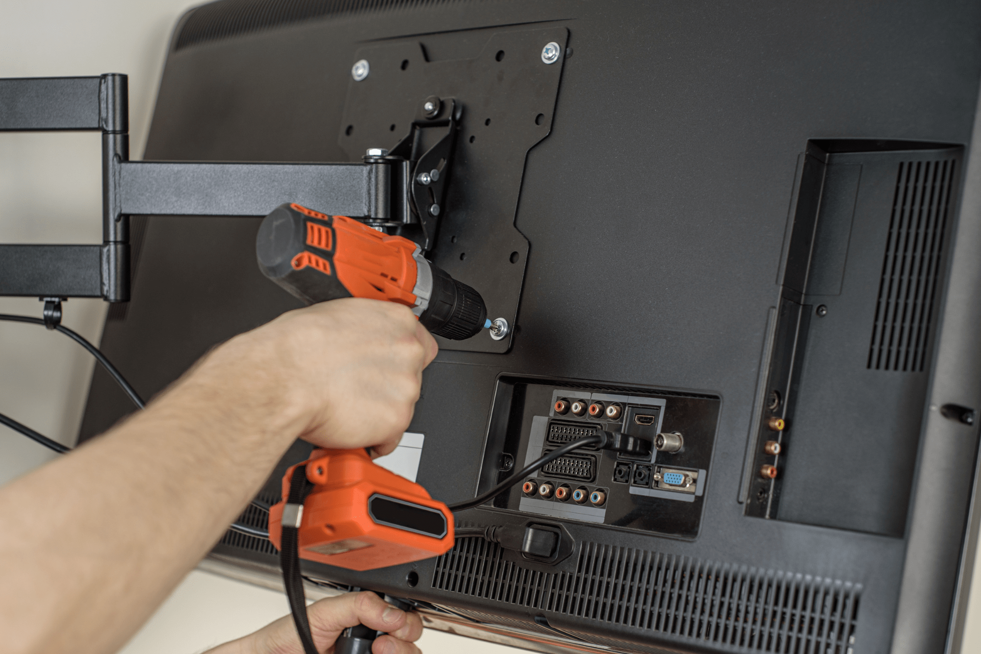 Man hands installing mount TV on the wall